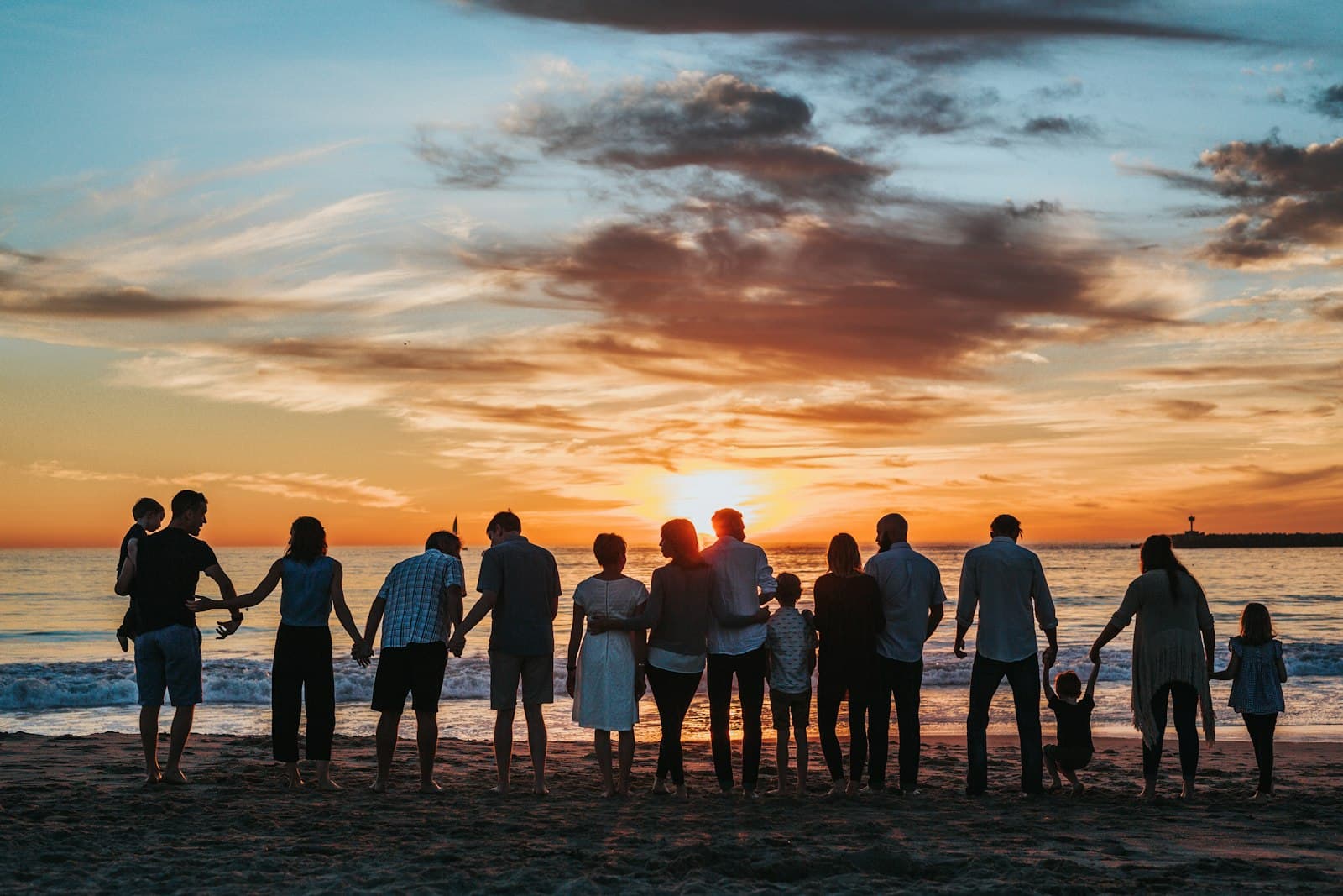 A family walking together along a beach at sunset