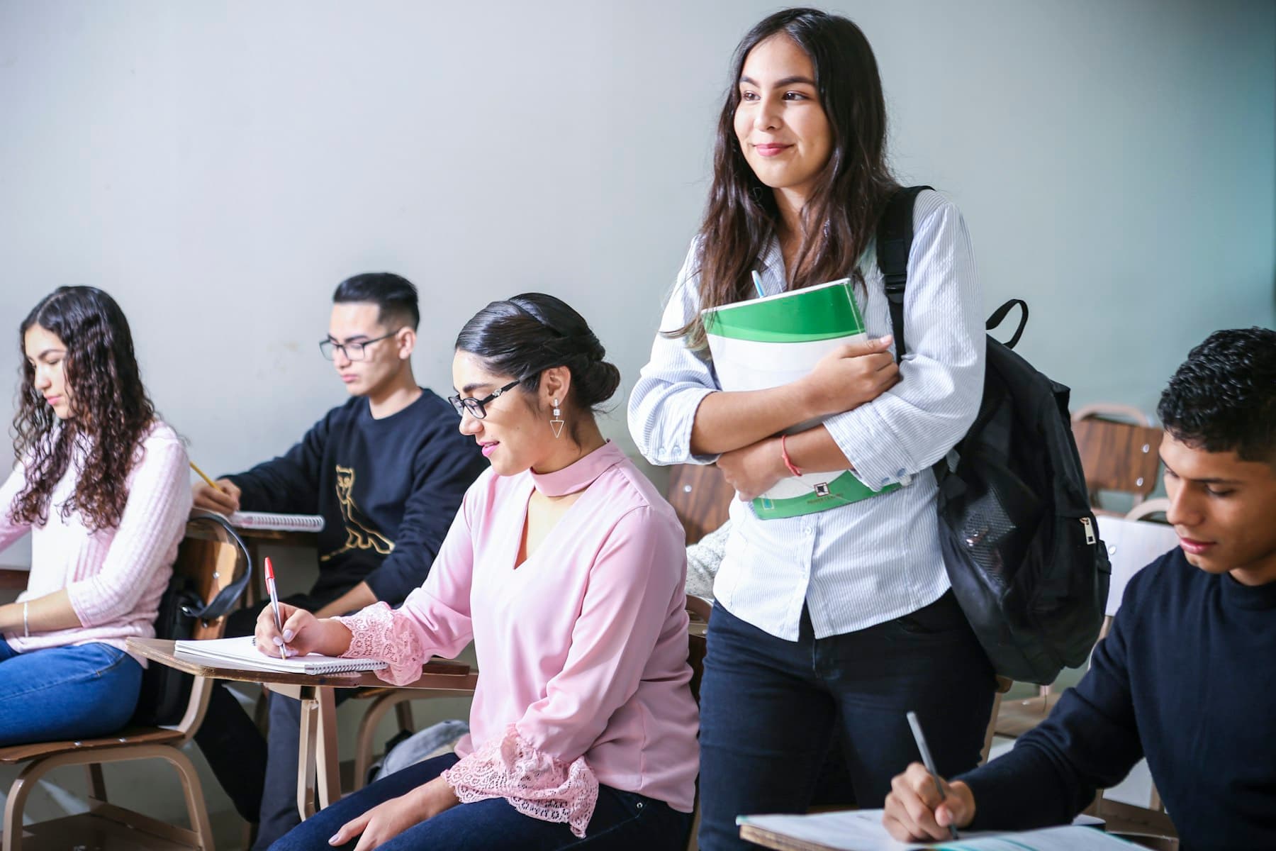 Students taking notes in a bright classroom