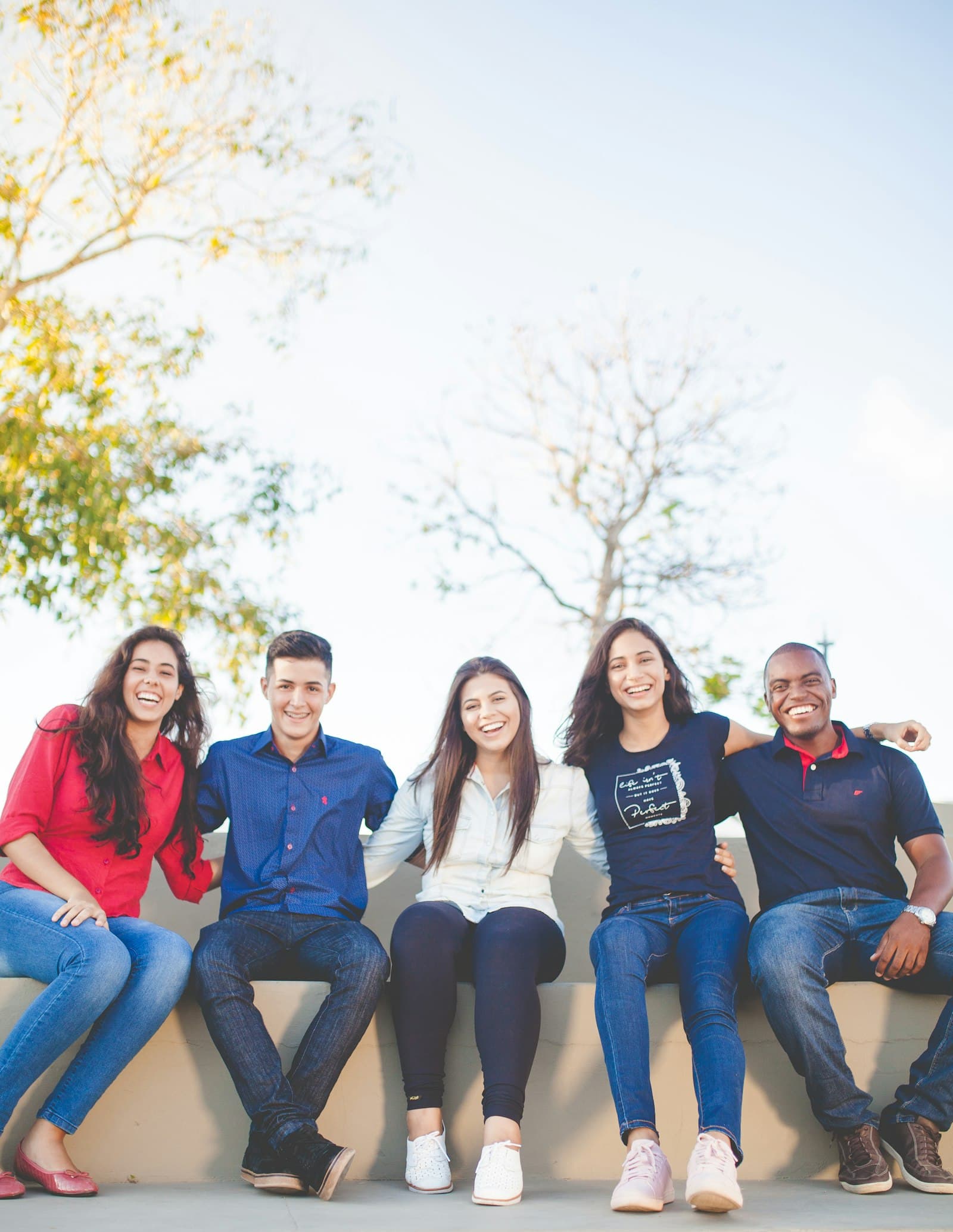 A group of smiling students sitting together outdoors
