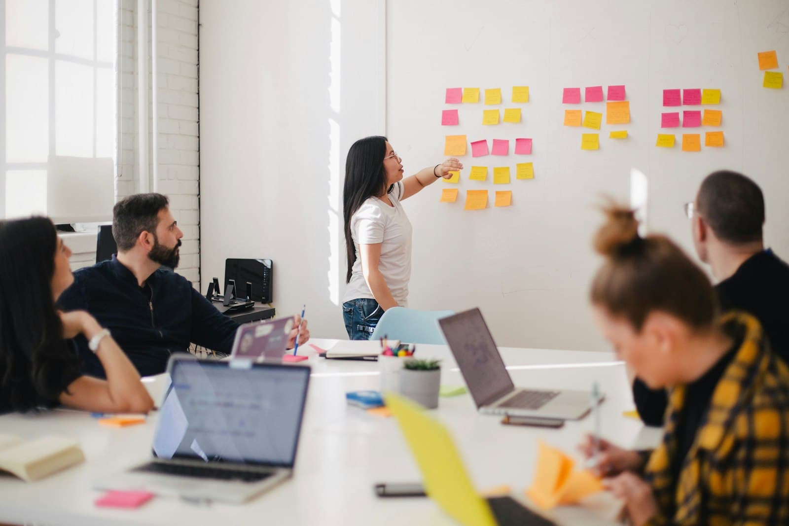 A team mapping out a project with sticky notes on a whiteboard