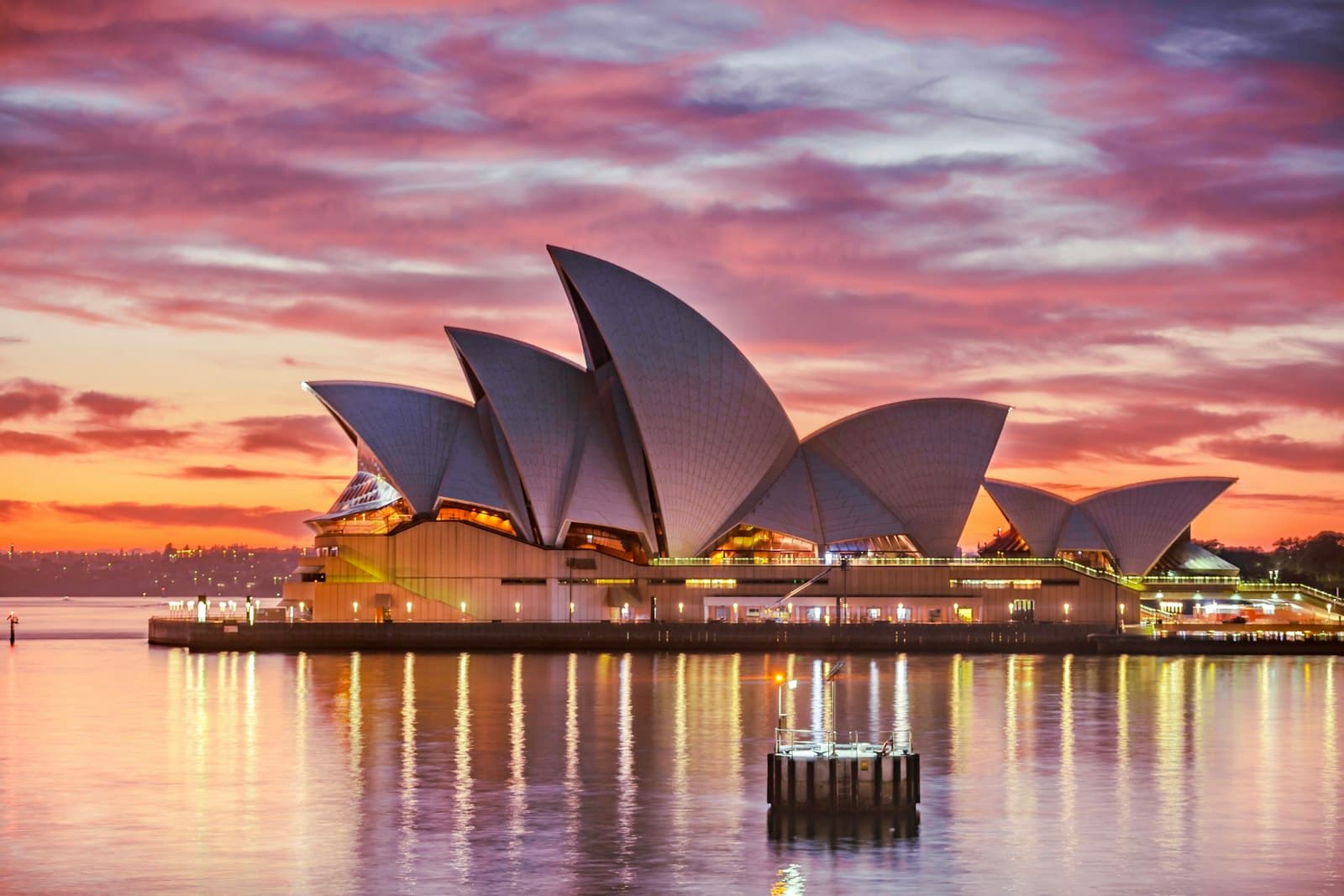 The Sydney Opera House reflected in the harbour at sunset
